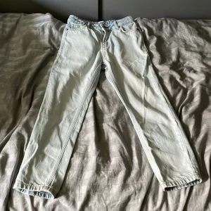 Ljusblå loose fit jeans från Grunt - Säljer ett par ljusblå loose fit jeans från Grunt i modellen Street Loose Track Stein. Jeansen har klassisk femficksdesign, raka ben och är tillverkade i bomull. Snygga kontrastsömmar och justerbar midja med knappresår.Jeansen har en liten fläck bak men märks inte så mycket!