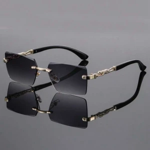 Svarta kantlösa solglasögon med gulddetaljer - Stilrena solglasögon med kantlösa, fyrkantiga svarta glas och snygga guldfärgade detaljer på skalmarna. Skalmarna är svarta med dekorativa guldelement som ger en lyxig känsla. Perfekta för dig som vill sticka ut med en modern och exklusiv look. PRISET GÅR ATT DISKUTERA!