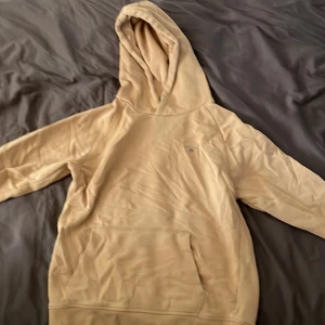 BEIGE GANT HOODIE - Beige Gant hoodie använd många gånger, hoodien har några små färgfläckar (inte särskilt synliga) som inte gått bort i tvätten. Storlek 158/164 men har troligtvis krympt en del i tvätten
