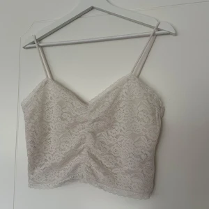 Topp - Kort topp med spets och dragkedja på sidan. Använd men hel och fräsch!