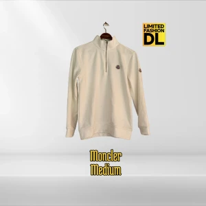 Vit half zip tröja från Moncler - Säljer en stilren vit långärmad tröja från Moncler med half zip och hög krage. Tröjan har Moncler-logga på bröstet och är tillverkad i mjuk bomull. Perfekt för dig som gillar clean och exklusiv streetwear.