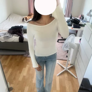 vit tajt tröja - Säljer en stilren vit långärmad topp från ginatricot med en liten offshoulder-skärning. Tight passform som framhäver figuren och passar perfekt till jeans eller kjol. Mjuk och stretchig i bomullsmix, enkel att matcha och superbekväm att bära. Storlek S