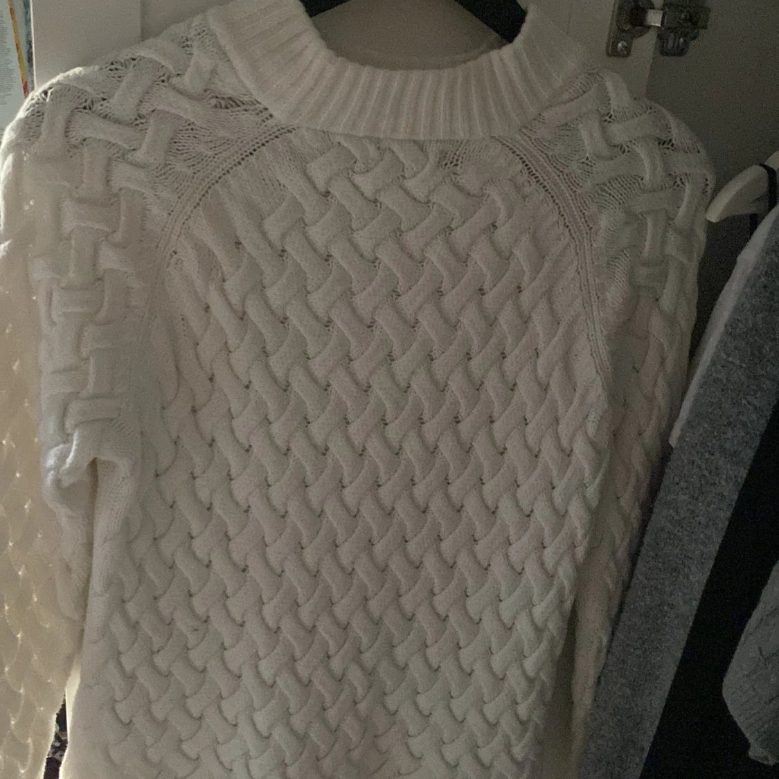 Vit stickad tröja med flätmönster