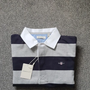 Randig pikétröja från GANT - Tröjan är aldrig använd och är helt ny. Storleken på tröjan är 158/164 men passformen är bred. Säljer denna tröja då den är för stor i passformen och inte kan skicka tillbaka. Tröjan är perfekt till skolan eller finare tillfällen och passar personer som är bredare i storleken. Ny pris ca 800, mitt pris 429. Det är bara att höra av sig vid funderingar! Kan gå ner I pris vid snabb affär!