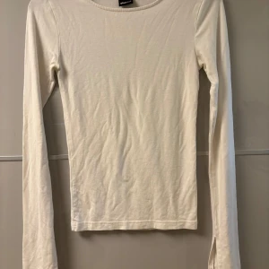 Vit långärmad tröja från Gina Tricot - Säljer denn vita basic soft touch tröja från gina tricot, med slits på armsluten, då den inte kommit till användning utan endast använd en gång. Storlek XXS.
