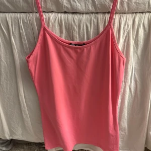 Rosa linnetopp från Zara - Enkel och snygg rosa linnetopp från Zara med smala axelband och rak passform. Perfekt att styla med jeans eller kjol för en fräsch look. Mjuk och skön bomullskänsla, passar perfekt till varma dagar.