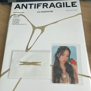 ANTIFRAGILE (2nd Mini Album) [IRIDESCENT OPAL] - Snyggt designad fotobok från K-popgruppen LE SSERAFIMs andra mini album 'ANTIFRAGILE'. Innehåller exklusiva foton, samlarkort och stickers – perfekt för fans som vill ha något unikt och inspirerande i sin samling. Kommer med kaxiga photocard. Vissa klistermärken är använda som ni kan se på bilden. Köpt från bengans i Sthlm 