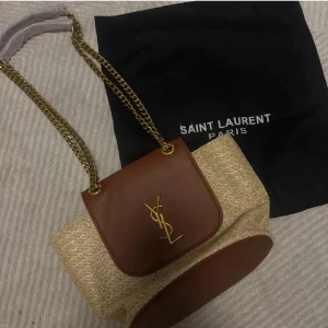 YSL Summer Bag - TVÅ i lager, Säljer en jätte fin YSL beach bag med tillkommande dustbag. Väskan är helt ny och 100% oanvänd. Måtten är 29x19 cm. Jätte rymlig på insidan och loggan inristad på detaljerna. Tillkommer även ett verifikat kort.🌴Pris kan diskuteras vid snabb affär ❤️
