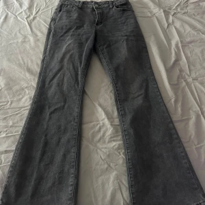 Grå bootcut jeans med hög midja - Snygga grå jeans med bootcut-modell och hög midja. Jeansen har klassisk femficksdesign, bälteshällor och dragkedja fram. Materialet är jeans med en lätt tvättad look som ger en cool vibe. Säljer pågrund av att dom inte sitter fint på mig