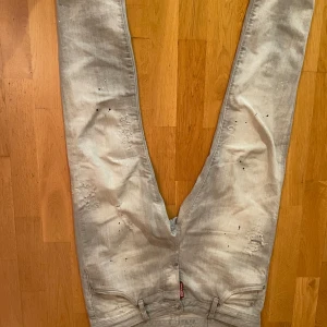 Dsquared2 jeans - Jättebra skick ljusgråa nästan på vita, blåa prickar på jeansen. Fickorna är små storlek 42 motsvarar ungefär 170-175. 