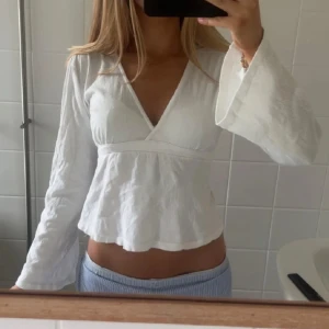 Vit omlottopp med knytband från Gina - Så fin knyttopp från Gina Tricot, perfekt till sommaren! Jätteskönt material, går att anpassa till din kroppsform med bandet där bak. I nyskick! 🤍🤍🤍