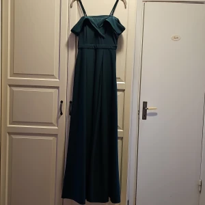 Grön långklänning från SHEIN - Mörkgrön axelbandsklänning från SHEIN i lång modell. Klänningen har smala axelband, offshoulder-detalj och markerad midja. Har endast användas på min bal❤️