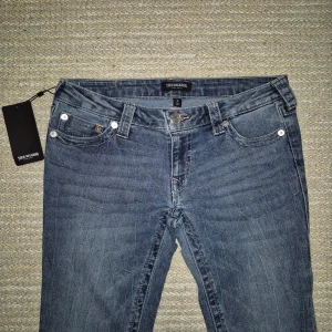 True Religion Jeans - Helt oandvända True religion jeans i storlek 28, passar M. De är lowwaist bootcut i modellen Joey flare och i färgen Ghost wave. Jag har köpt dem på Nelly där ordinarie pris är 1399.