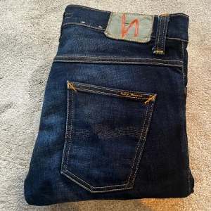 Blå nudie jeans - Skick: 9/10, hög potential för en skön wash - Storlek: W30 L32 modell: grim tim- Längd:105cm Midja:40cm ben:17cm - Nypris: 2200 kr+