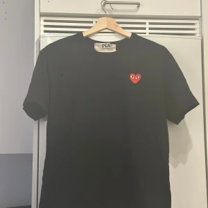 Comme des Garçons Play - Svart t-shirt från Comme des Garçons Play med det ikoniska röda hjärtat med ögon broderat på bröstet. Använt i bra skick.