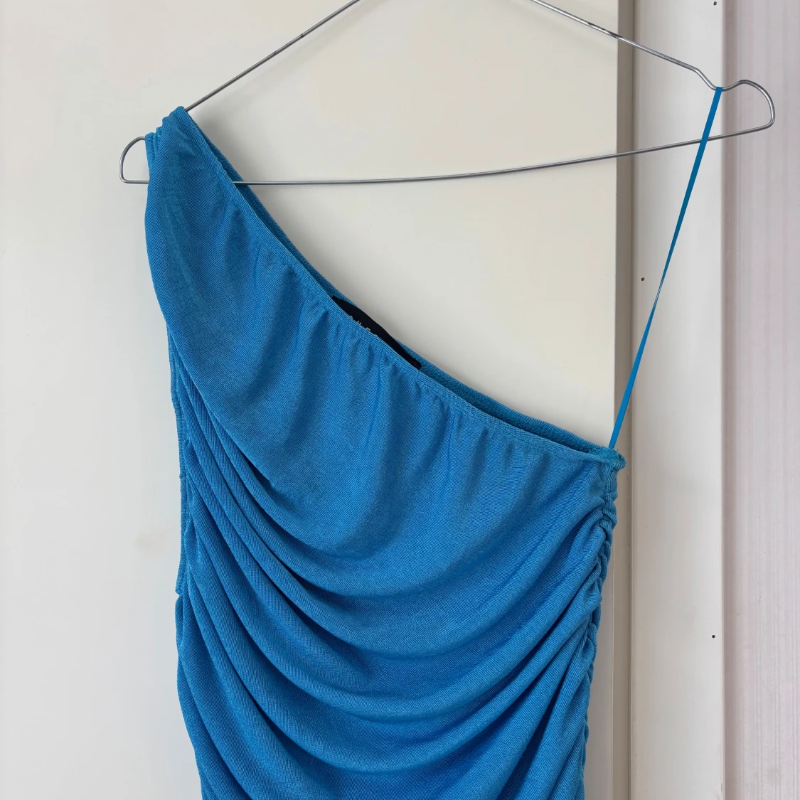 Blå one shoulder draperad klänning