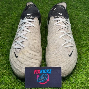 Phanthom GX - Nike Phantom GX Elite FG – Football Boots  Selling a pair of Nike Phantom GX Elite FG boots, built for players who want precision, control, and creativity on the pitch. 	•	Size: 42 	•	Condition: Lightly Used 	•	Color: White/Black/Bright Crimson 	•	Technology: 	•	Gripknit Upper: Special textured material for superior touch and control in all weather conditions. Retail Price: 300€