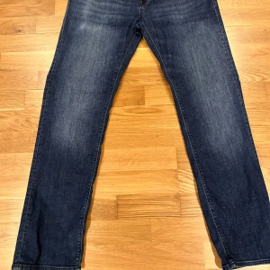 Mörkblå jeans från BOSS - Säljer ett par mörkblå jeans från BOSS med stretch. Klassisk femficksmodell och raka ben. Jeansen har diskreta slitningar framtill och bakfickor utan detaljer. Perfekta för en stilren look. Storlek 38/33. Använda 1-2 gånger.  Nypris 1 799. Pris kan diskuteras 