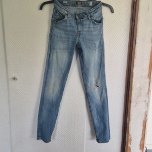 Ljusblå skinny jeans från Jack & Jones - Säljer ett par ljusblå skinny jeans från Jack & Jones med slitningar på ena benet och klassiska fem fickor. Jeansen har normal passform i midjan och smalare ben. Perfekta för dig som gillar en avslappnad men ändå trendig look. Storlek 152, 12 år. Tvättade i sköljmedel och hund finns i hemmet