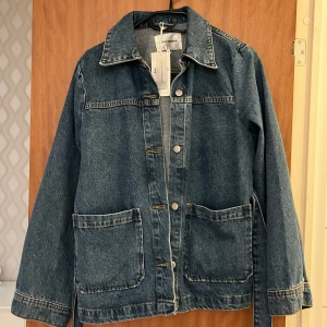 Jeansjacka med bälte från Carin wester  - Säljer en klassisk blå jeansjacka från Carin wester. Jackan har stora framfickor, knappar framtill och ett matchande bälte i midjan. Perfekt för dig som gillar tidlös denim och vill ha en jacka med snygg passform. Den är slut i lagret‼️