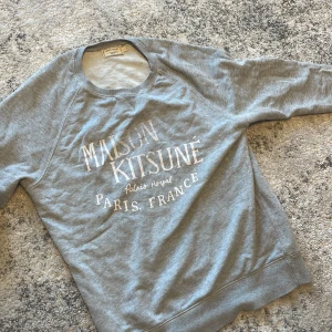 Grå sweatshirt från Maison Kitsuné - Säljer en grå sweatshirt från Maison kitsune. Den e i storlek L men sitter som M