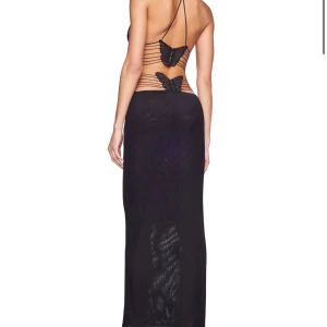 Svart långklänning med fjärilsdetaljer och öppen rygg - Säljer en svart långklänning med smala axelband, öppen rygg och dekorativa fjärilar i ryggen. Klänningen har tight passform upptill, v-ringning och tunna snören i sidorna. Perfekt för dig som vill sticka ut med unika detaljer. Bara använd 1 gång! Kan skicka fler bilder 🩷🩷