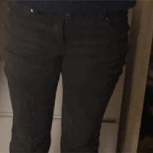 jeans - Säljer ett par svarta jeansbyxor med klassisk femficksdesign och normal passform. Byxorna har knapp och dragkedja framtill och är perfekta till många olika outfits.