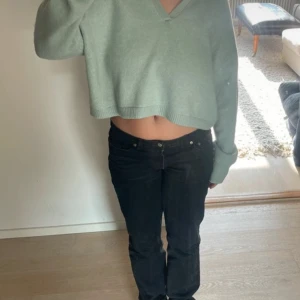 Ljusgrön croppad tröja från Zara - Säljer en ljusgrön croppad tröja från Zara med v-ringning och krage. Tröjan har långa ärmar och är tillverkad i ett mjukt material som ger en avslappnad look. Perfekt för en stilren och bekväm outfit.