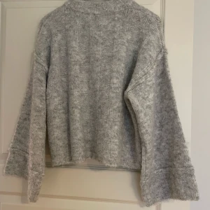 Grå stickad tröja från Karen by Simonsen - Säljer en mysig grå stickad tröja från Karen by Simonsen. Tröjan har en lös passform , använd en gång 