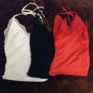 Set med tre spetslinnen - Säljer ett sett med tre super snygga linnen i rött vitt och svart🤩🤩. Alla har spetsdetaljer vid bysten och knytband i nacken. 