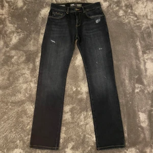 Mörkblå jeans från LTB - Snygga mörkblå jeans från LTB med en straight passform och midwaist. De har en klassisk femficksdesign och slitna detaljer för en trendig look. Perfekta för en avslappnad stil. Jeansen är i storlek 31/32 men sitter som 30/32