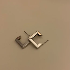 Fyrkantiga silverörhängen - Snygga fyrkantiga örhängen i silver med en modern och stilren design. Perfekta för att ge en extra touch till din outfit. Jag fick dom i en mystery bag som jag köpte här på plick men dom är inte riktigt min stil så jag hoppas att jag kan sälja dom till någon som tycker om dom mer än vad jag gör. De kommer även med pluppar till. Läs gärna min bio innan du köper✨