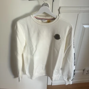 Vit Moncler tröja - Säljer en vit moncler tröja som är använd ett fåtal gånger, i princip ny! Scan koden dyker upp och plagget har inga defekter!