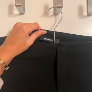 Kostymbyxor - Svarta midwaist kostymbyxor med slit. Dessa ger en stilren look då de är simpla utan extra detaljer som en visande gylf osv.