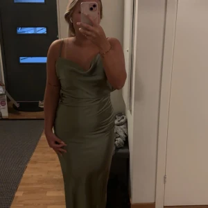 Grön balklänning  - Snygg grön balklänning från Boohoo i ett glansigt material. Klänningen är helt ny och har köpts för 800kr. Jag säljer den för att jag beställde i fel storlek, så den är helt oanvänd.