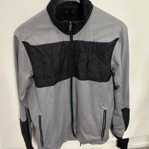 Grå och svart jacka från Galvin Green - Säljer denna snygga jackan från Galvin Green, sprillans ny och helt oanvänd. Storlek M. Passar mig som är 186. Skriv i dm för eventuella byten eller liknande. 