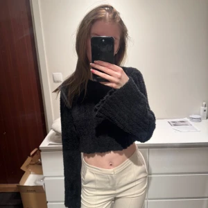 Svart croppad stickad tröja - Svart croppad fluff tröja med utsvängda ärmar. Från nakd i xxs. Typ aldrig använd