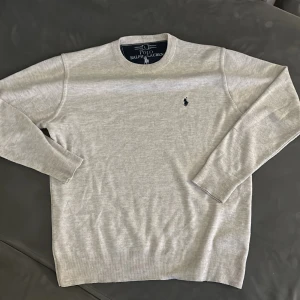 Grå tröja från Polo Ralph Lauren - Säljer en beige tröja från Polo Ralph Lauren med det klassiska broderade logotypen på bröstet. 7/10 skick, pris kan diskuteras