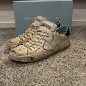 Vita sneakers från Philippe Model - Snygga vita sneakers från Philippe Model med klassisk design och snörning. Skorna har en stilren look med detaljer i skinn och en robust sula. Perfekta för en avslappnad stil. Men lite sönder på baksidan. Men riktig snygga.