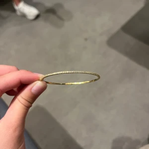 Tunt guldarmband med glittriga stenar från ANI - Ett fint tunt guldarmband från ANI Jewellery. Använd få gånger. Nypris 1000