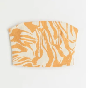 Mönstrad bandeau tubtopp H&M - Snygg bandeau tubtopp från H&M med orange och vit zebramönster. Toppen är ribbad och ärmlös. Har prislappen kvar!