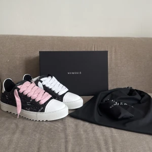 Numeris sneakers med rosa och vita snören - Unika sneakers från Numeris med chunky vit platt sula, svart och vit ovandel i textil och skinn, samt coola snören i både rosa och vitt. Detta är en riktigt fin och unik sko. De är helt nya. Ny pris 2400. Mitt pris 1450