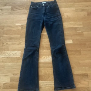 Svarta bootcut jeans - Snygga svarta  jeans med bootcut passform och klassisk femficksdesign. Jeansen har en något högre midja och är tillverkade i ett mjukt denimtyg som ger en skön känsla. Perfekta för dig som gillar en tidlös och avslappnad stil.