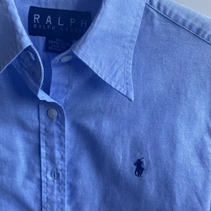 Ljusblå skjorta  - Snygg Ralph lauren skjorta i mycket fint skick. Storlek L i barnstorlek. Skulle säga att den passar S. Priset är inte hugget i sten och tveka inte på att fråga om du undrar något. 