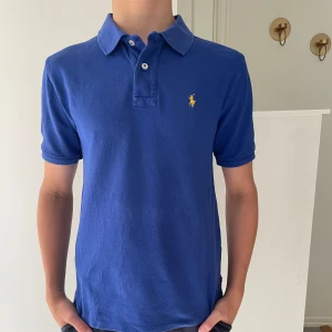  Polo Ralph Lauren piké  - Klassisk blå piké från Ralph lauren! Piken är i bra och sparsamt. Killen på bilden är c.a 170cm och pikén sitter lite litet och tajt! Tveka inte på att höra av er vid minsta fundering. Bundle är möjligt!
