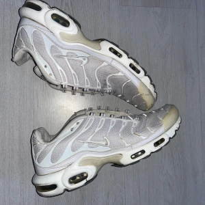 Nike Air Max  - Nike Air Max sneakers i vitt med mesh och syntetpaneler, ikoniska vågformade detaljer och synlig Air-dämpning i sulan. Snygg sportig look med reflekterande inslag och klassisk Swoosh-logga på sidan. Perfekta för dig som gillar streetwear och komfort.