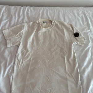 Vit t-shirt från C.P. Company - Säljer en stilren vit t-shirt från C.P. Company i mjuk bomull.  Är du intresserad av plagget är de bara att skriva.  Vill du ha billigare genom bundle eller lika feta kläder kolla bara in min profil och gör ett bundle och skriv till mig