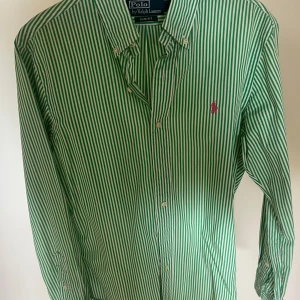 Ralph Lauren skjorta - Säljer en randig grön vit Ralph lauren skjorta svin najs combo snygg till sommaren. Riktigt bra skick på skjortan knappt använd