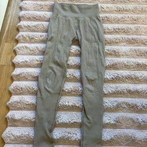 Ribbade leggings i beige XS/S - Supersköna ribbade leggings i beige med hög midja. Tillverkade i stretchigt material med 96% polyester och 4% elastan. Perfekta för en chill vardagslook, ska på träning eller när du bara vill ha något bekvämt på dig.