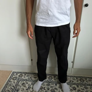 Linne byxor från Zara - Svarta byxor från Zara i storlek S med elastisk midja och snörning. Byxorna har en rak passform och är tillverkade i mjukt bomullsmaterial, vilket gör dem riktigt sköna att ha på sig. Perfekta för en chill och stilren look.